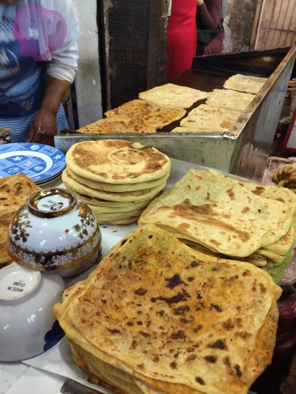 Traditional Moroccan msemen being prepared on a hot plate as part of authentic Marrakech street food.